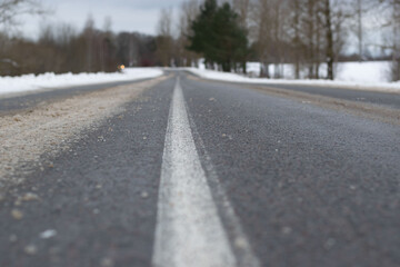 Icy winter highway processed by road services. Danger of movement, the need to reduce speed and increased attention when driving, a high probability of an accident