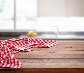 Red checkered tablecloth on wooden table. Napkin close up top view mock up. Kitchen rustic background.