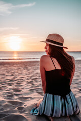 young woman with hat on beach on vacation