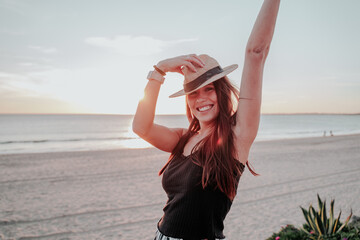 young woman with hat on beach on vacation