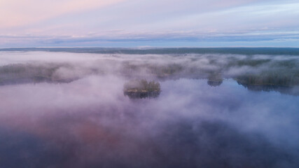 Fototapeta premium Early morning with mist above the lake and forest. Aerial view. Drone photography.