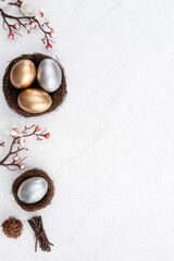 Obraz na płótnie Canvas Design concept of Golden and silver Easter eggs in the nest with white plum flower.