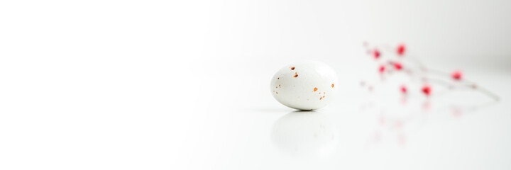 Easter minimal composition with eggs and flowers on the white background. Easter concept. Copy space. Banner.