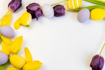 Paschal greeting card. Festive easter frame with colorful eggs and  tulips on  white background. Template with spring flowers, decoration design.