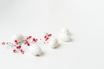 Easter minimal composition with eggs and flowers on the white background. Easter concept. Copy...