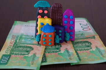 A toy house and paper money on the table.
