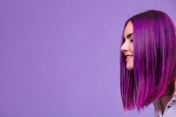 Model girl young beautiful stylish with hair dyed purple on violet background