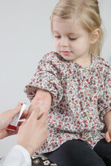 Mother applaying ointment onto red and itchy eczema on her daughter's arm. Toddler girl suffering from atopic dermatitis.
