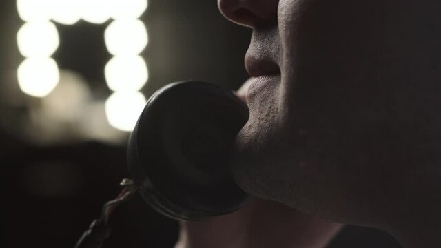 Extreme close up look at mouth of man who talks on old vintage retro phone. There light in the back, counter. beautiful movie look of chatter on phone.