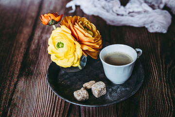Tasse de café expresso sur la table avec un petit bouquet de fleurs renoncules - Ambiance florale à la maison