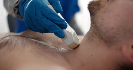 Close up of doctor checkup and scanning thyroid gland of male patient at ultrasound