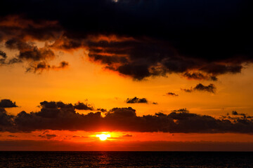 Dramatic sunset over ocean. Sky with clouds.