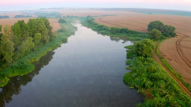 4k drone flight up footage (Ultra High Definition) of small foggy pond in Ternopil outskirts. Aerial morning view of hte Ukrainian countryside with field of wheat. .