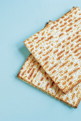Matzo on a blue background. Happy Passover concept. Traditional Jewish food for Pesach.