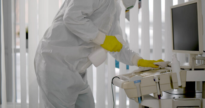 Medical Worker In Ppe Doing Sanitization Of Equipment In Hospital Room