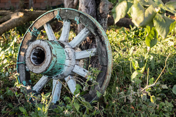 Old cart wheel on the farm. Wooden wagon wheel.