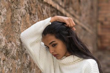Portrait of a pensive and contemplative brunette woman running her hand through her hair