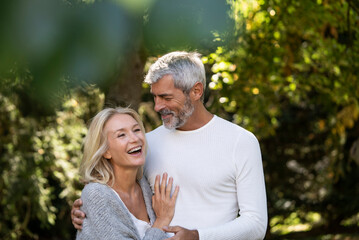 Happy mature couple embracing in backyard