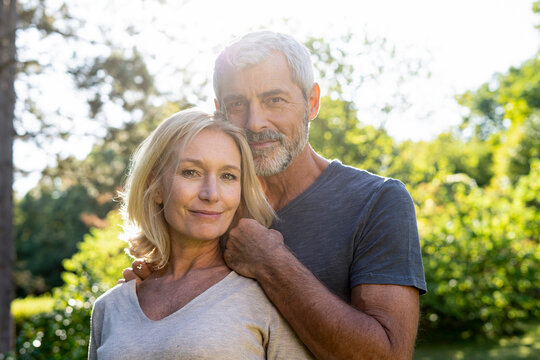 Portrait of smiling mature couple standing in backyard