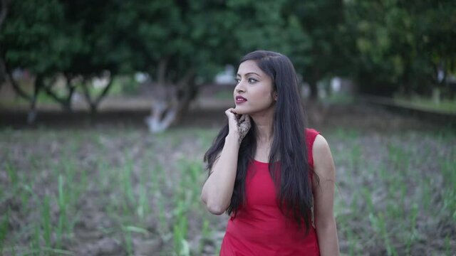 Indian village girl walking in greenfield wearing Indian traditional Suit. Walking in the agricultural field. High-quality 4k footage