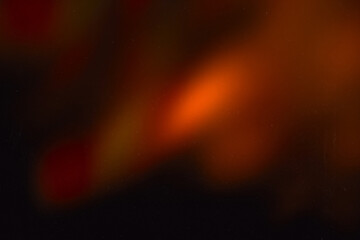 Blur colorful warm rainbow light leaks on black background with dust texture. Defocused abstract...