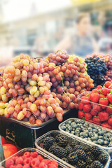 Bunches of grapes on the counter. Green, red bunches of ripe grapes are laid out on the counter of the farmers ' market. The fruit is ready for sale