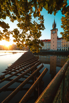 View of clock tower reflecting in Vltava River in Prague city