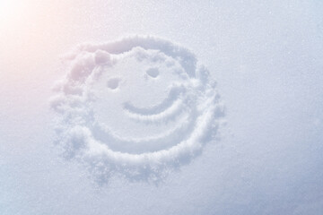 Drawing of a smiley in the snow, a ray of light. Top view