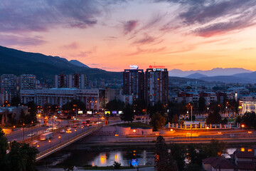 Elevated view of traffic on bridge passing over Vardar River with Skopje cityscape in background