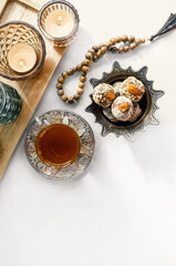 bowl with various pieces of Turkish delight locum and black tea with mint on a light background. Oriental sweets. copy space