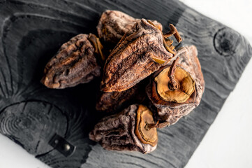 Dried persimmons on a wooden board. Dehydrated fruit. Top view