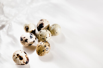 Quail eggs on a white background, hard light, shadows. Food background. Selective focus.