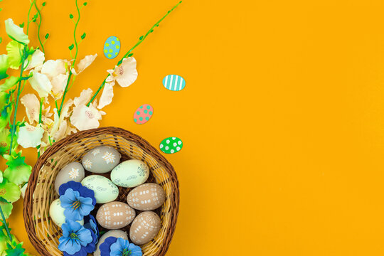 Happy Easter babckground with nests decoration with colorful eggs and spring flowers, greeting card concept