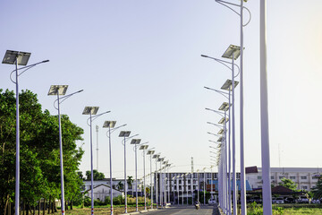 Obraz premium Solar cell lighting bulb with green trees on the road