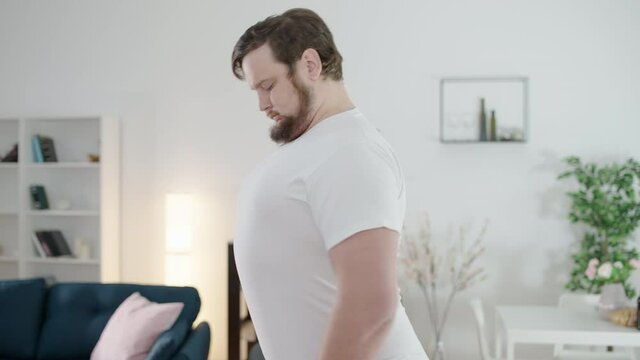 Overweight man sucking in stomach, pretending to be slim, weight gain, calories