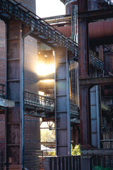 Fototapeta premium Sun shining through scaffold and ventilation pipes in LAndschaftspark Duisburg