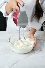 pastry chef preparing mixing meringue for cake and bakery.
