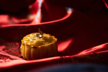 Mooncake a Chinese traditional pastry for Mid-Autumn festival. set on red chinese fabric.