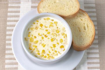 Corn flakes with gratin cheese, accompanied by bread on wooden background