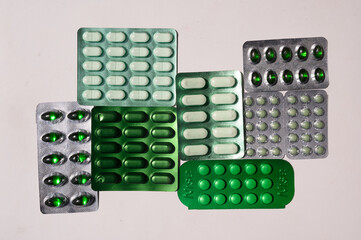 Green Color Capsule / Pills - Medicine on white background in natural light. Health themes.
