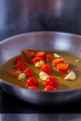 Roasted cherry tomatoes cooking food for italian cuisine, tomato sauce for pasta, mediterranean diet concpet, detailed view of pan with fried tomatoes