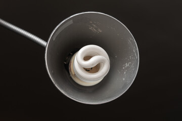 Old desk lamp, dusty, close up of a white light bulb.