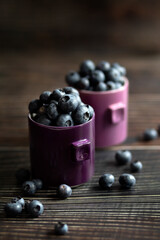 Berries blueberries in a cup on a wooden table. Place for your text.