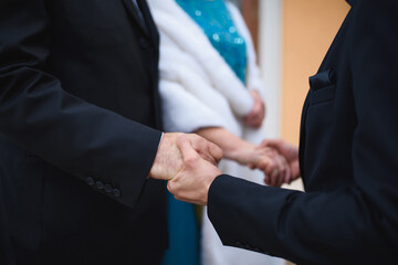 man holding hands of bride and groom