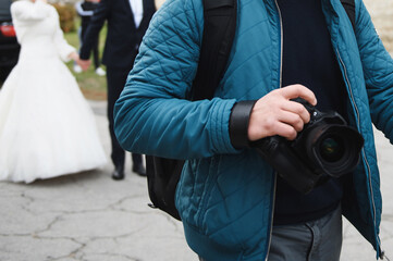 photographer with camera and newlyweds