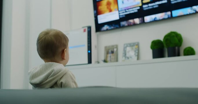 A child watches TV and looking for cartoons.