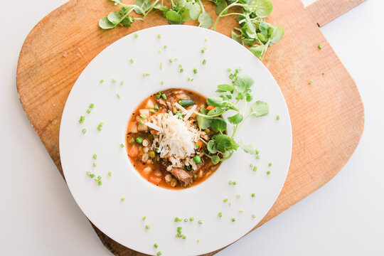 healthy vegetable soup in white bowl with decorative chives
