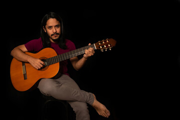 Man playing guitar with black background