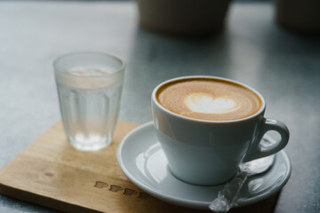 White coffee cup of heart shape  latte art on wood table background.