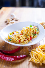 Spaghetti with chili pepper and tomato sauce. Vegetarian pasta with Parsley chilli and parmesan cheese. Fresco Pasta. Italian food. Fine dish. Horizontal frame. Macro food photography
